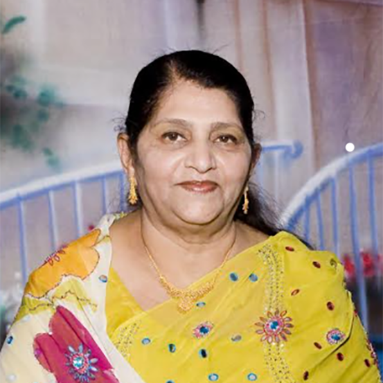 Khadiza Moosa smiles wearing a yellow sari.