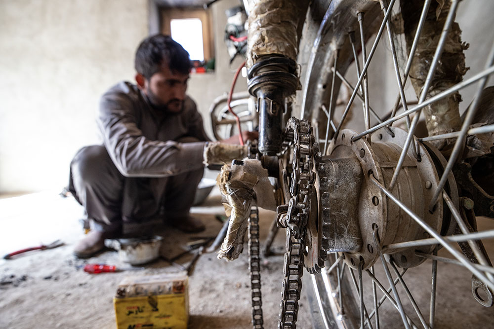 'Khudadad' repairing a motorcycle.