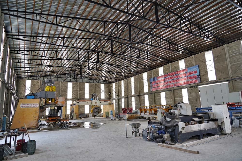 Interior of the Pamir Stone factory showing several large machines.