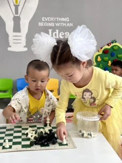 Children play with a chess set.