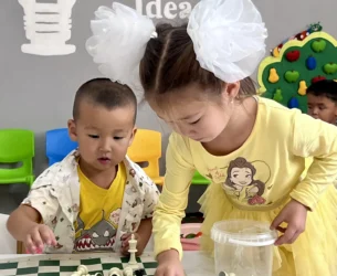 Children play with a chess set.