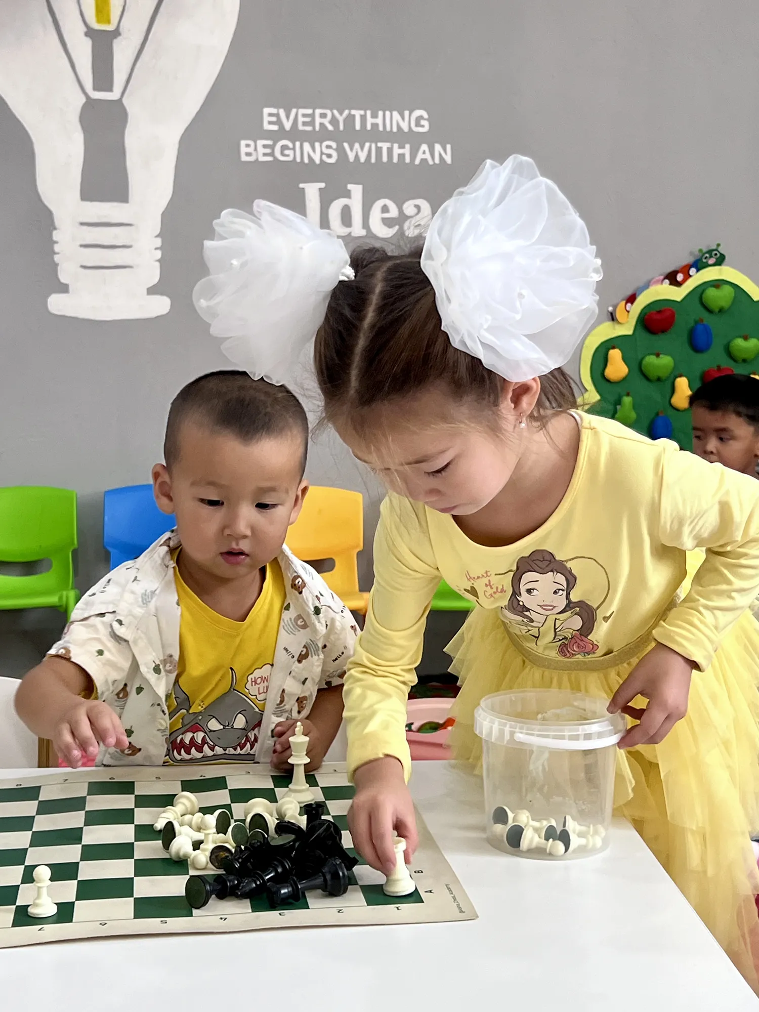 Children play with a chess set.